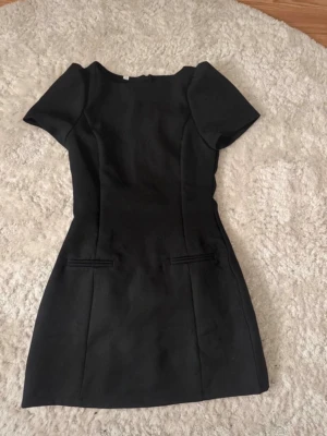 Mini klänning  - Säljer en svart figursydd kort kostym klänning med puffärmar och rund hals. Nästintill identisk till Zaras virala Klänning! Den har ordentligt tyg, dragkedja i ryggen och inbyggda shorts så som orginal. Säljer den vidare så vet tyvärr inte vart den är köpt! DE ÄR INTE ZARAS 💕💕