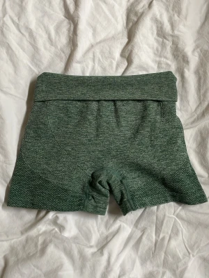 Gröna träningsshorts - Mörkgröna shorts med bred, hög midja som kan vikas ned + tight passform. Perfekta för träning eller gymmet. Materialet är stretchigt.