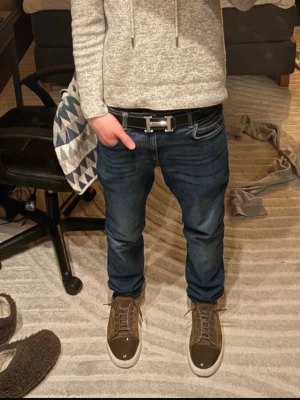 Bruna sneakers från Lanvin - Snygga bruna sneakers från Lanvin med ovandel i mocka och tåparti i blankt material. Skorna har vita sulor och bruna skosnören. Perfekta för dig som vill ha en stilren och exklusiv look med en touch av lyx. De är stora i storleken så passar för dig med 41 i skostorlek.