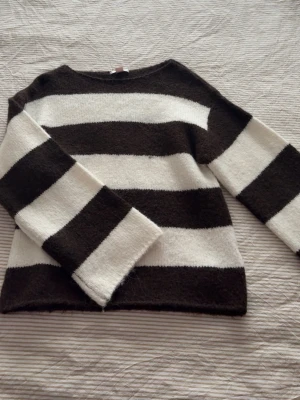 Randig stickad tröja  - Säljer denna randiga brun/vita tröja från Gina barnavdelning storlek S. Tröjan har använts endast en gång. 