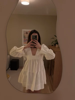 Vit klänning i skjortmaterial med knytdetalj - Helt otroligt fin klänning i skjortmaterial med fin knytning vid vid ärmslutet. Fina detaljer och inte genomskinlig. Så ledsen att den inte passar mig, tror den passar något kortare personer. Jag är 170cm och den blir för kort vid brösten där den inte håller sig på plats. 