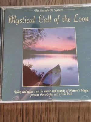 CD Mystical Call of the Loon - CD-skiva med avslappnande naturmusik från serien The Sounds of Nature. Omslaget visar en kanot på en spegelblank sjö i solnedgång. Perfekt för dig som gillar lugnande ljud och naturens magi. Utgiven av Elap Music 1994.