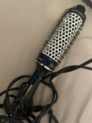Björn Axén Tools varmluftsborste - Säljer en svart och silver varmluftsborste från Björn Axén Tools med keramisk och turmalinbeläggning. Borsten har integrerat värmesystem och sladd, perfekt för att styla håret och skapa volym. Smidig design med borstpiggar och tydliga knappar. Ny och köpt förra året endast andvänd 1 gång då jag köpte den i 38 mm men sökte annan modell. Köpt för 1000kr