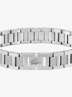 Silverfärgat armband från Lacoste - Snyggt armband i silverfärgat rostfritt stål från Lacoste. Länkarna har en mix av släta och mönstrade ytor samt den klassiska krokodilloggan ingraverad på mitten. Perfekt accessoar för dig som gillar stilrena detaljer och ikoniska märken.