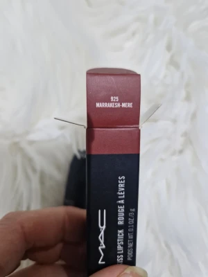 MAC Powder Kiss Lipstick Marrakesh-Mere - MAC Powder Kiss Lipstick i nyansen 925 Marrakesh-Mere. Ett matt läppstift i en varm, rödbrun ton. Hylsan är svart med silverdetaljer och har den klassiska MAC-formen. Perfekt för dig som vill ha en mjuk, suddad finish på läpparna.