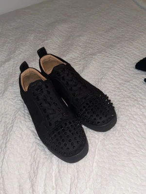 Christian Louboutin sneakers  - Säljer svarta Loubs med nitar. Välvordade men använda förstås. Köpt många år sen bara legat i garderoben ganska länge oanvänt. Tvättas innan de skickas, medföljer inte original kartong då jag använder. Finns definitivt skavanker därav 90% billigare än ordinarie pris, Pris diskuteras vill bara bli av me dem 