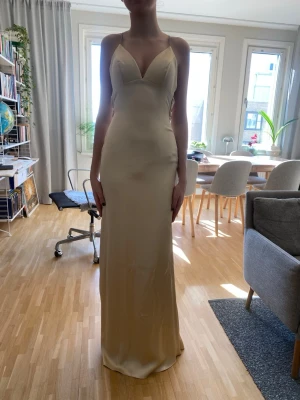 Lång balklänning med slits - Säljer min fina balklänning från dressroom, endast använd en gång! Den har en slit vid vänstra benet och stängs med dragkedja i ryggen. Den är lite för stor för mig i kupan som man ser. Nypris 2000kr. 