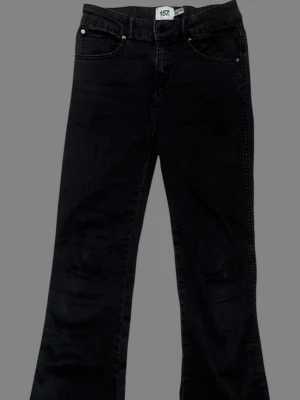 Svarta bootcut jeans från 157 - Snygga svarta bootcut jeans med klassisk femficksdesign och utsvängda ben. Jeansen har två fickor med lock bak och är tillverkade i ett mjukt denimtyg som ger en skön passform. Perfekta för dig som gillar en retroinspirerad look.