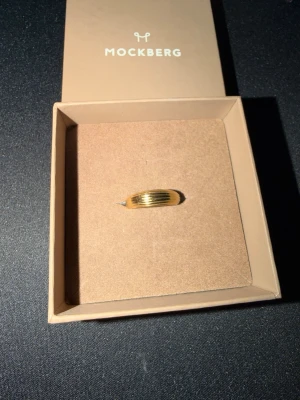 Guldfärgad ring från Mockberg - Guldpläterad ring från Mockberg.  Kommer i originalask. Storlek 17