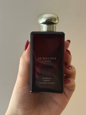 Jo Malone Scarlet Poppy parfym - Scarlet Poppy Cologne Intense från Jo Malone London. Perfekt för dig som gillar exklusiva och djupa dofter.De vilda stäpparna i sydvästra Asien täckta av de extravaganta blommorna från stora röda vallmoblommor. Deras överdåd förstärks av sammetslen iris och den söta dekadensen hos tonkabönan. Häpnadsväckande och elegant. 100ml, knappt använd