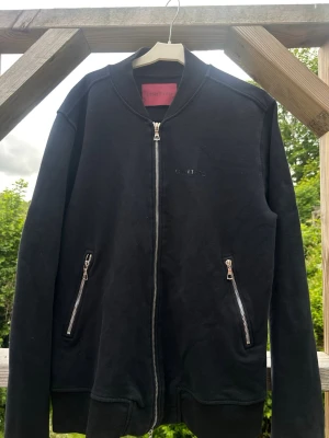 Svart zip hoodie från Limitato - Snygg svart hoodie från Limitato med dragkedja framtill och två fickor med silverfärgade dragkedjor. 