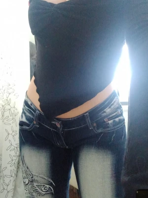 Mörkblå jeans med tribaltryck crazy age - Säljer ett par mörkblå jeans från crazy age med coolt tribaltryck på benet och slitna detaljer. Jeansen har låg midja, kontrastsömmar och dubbla knappar i linningen. Bootcut