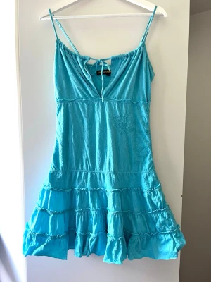 Vintage turkos sommarklänning  - En vintage turkos klänning från 200-talet med snörning längst fram och utsvängd kjol