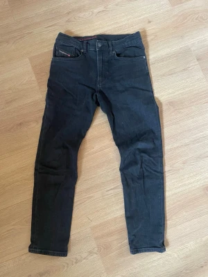 Svarta jeans från diesel - Snygga svarta jeans med klassisk femficksdesign. Jean vi sen har normal midja och gylf. Perfekta för en stilren och enkel look. 14Y