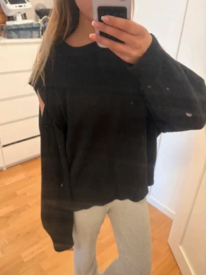 Svart oversized stickad tröja - Mysig svart stickad tröja i oversized modell med långa ärmar och rund hals. Tröjan har hål i axlarna som är fett snyggt! Säljer då den tyvärr inte var min storlek. Inte mina foton men kan skicka bilder på den privat!