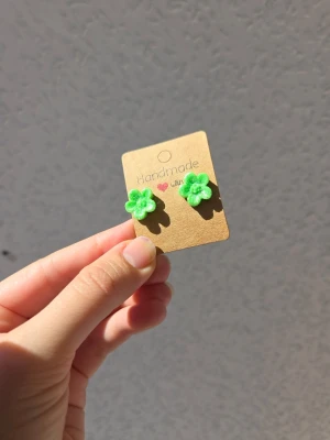 Handgjorda gröna blomörhängen - Supersöta handgjorda örhängen i form av små gröna blommor med glitter. Perfekta för dig som vill ha något unikt och färgglatt i sommar!. Örhängena är tillverkade för hand av mig i polymerlera. 