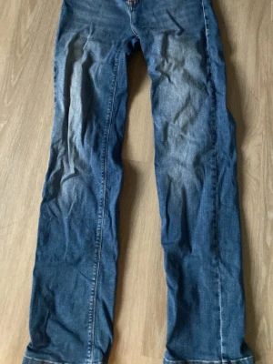 Blå klassiska jeans med raka ben - Snygga blå jeans med raka ben och klassisk femficksdesign. Jeansen har kontrastsömmar och en läderpatch bak i midjan. Perfekta till vardagslooken och passar till det mesta. Materialet är slitstarkt denim.