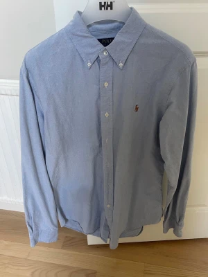 Blå skjorta från Polo Ralph Lauren - Tjena, säljer nu denna ljusblå skjorta från Ralph lauren. Den är i storlek L men passar både M och L. Tveka inte att göra av er vid frågor eller funderingar!