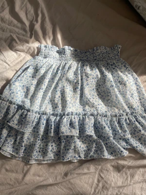 Blommig kjol - Säljer en fin blommig blå vit kjol från New Yorker i storlek S. Använd ett fåtal gånger och inga tecken på användning💕