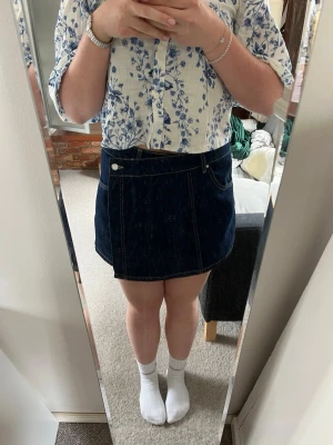 Mörkblå shorts jeans kjol  - Säljer en mörkblå shorts jeans kjol i kort modell.  Kjolen stängs med knapp och dragkedja framtill. Perfekt till sommaren . I storlek L (40). Från Zara 