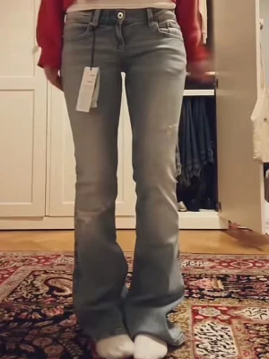 Ljusblå bootcut jeans med slitningar - inte mina bilder! Men säljer dessa jeans u storlek 32, tall. Endast använda ett fåtal gånger, super snygga! Älskar detaljerna på fickorna och hålen. Skriv för fler bilder