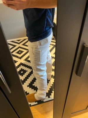Vita jeans från Lee - Säljer ett par snygga vita jeans från Lee med klassisk femficksdesign och raka ben. Jeansen har en diskret Lee-logga på bakfickan och är tillverkade i ett mjukt denimtyg. Perfekta för dig som vill ha en clean och fräsch look.