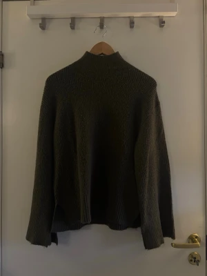 Mörkgrön stickad tröja 157 XS - Mysig mörkgrön stickad tröja från 157 med hög hals och avslappnad passform. Tröjan har långa ärmar och är tillverkad i ett grovstickat material som passar perfekt för kyliga dagar.Hör av dig om du har några frågor! 💗🫶🏼