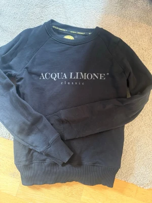 Svart sweatshirt från Acqua Limone - Säljer min Acqua Limone tröja då den inte kommer till användning, den ser helt ut jättebra skick. Och väldigt skön och mysig tröja.