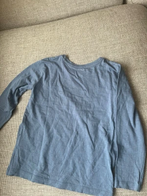 Blå långärmad tröja från 157 - En enkel blå långärmad tröja från 157 i 100% bomull. Tröjan har rund halsringning och en avslappnad passform, perfekt för en chill och bekväm stil.