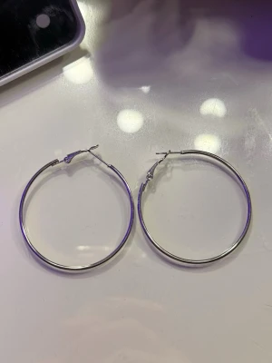 Olika storlekar hoops örhängen - Säljer ett olika stora, runda hoops i silverfärgad metall. Och ett par i guld. Klassisk och stilren design som passar till många olika looks. Perfekta för dig som gillar enkla men snygga accessoarer. Från dollarstore.