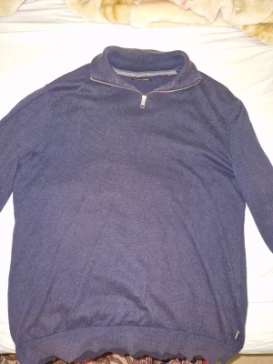 Mörkblå stickad tröja Jack & Jones - Snygg mörkblå stickad tröja från Jack & Jones med halv dragkedja vid halsen. Tröjan har hög krage och ribbade muddar vid ärmslut och nederkant. Perfekt för lager på lager och enkel att matcha med jeans eller chinos.