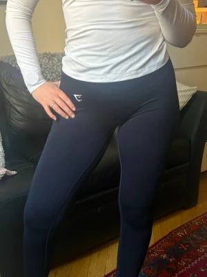 Svarta seamless tights från Gymshark - Säljer mina svarta lift seamless Gymshark tights! De är supermjuka och stretchiga i materialet och sitter så skönt på! Iom stretchen skulle jag säga att de definitivt även passar någon med storlek M. De har en lite högre midja och en diskret contour-effekt på rumpan som gör de så fina och smickrande!🖤 Har älskat dessa och använt en del så de har lite noppror på baksidan, men inga andra defekter som inte går att åtgärda! 😊 Ordinariepris 599kr