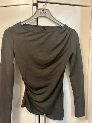 Mörkgrön långärmad topp från Gina Tricot - Snygg olivgrön  långärmad topp från Gina Tricot med rund halsringning och figurnära passform. Var tvungen o sälja då den ej passa och inte kunder returneras. Köpt för 300kr