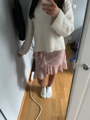 Blommig omlottkjol - Säljer en jättefin rosa omlottkjol med vita blommor. Använd fåtal gånger. Den passar perfekt till sommaren och är lätt att styla💕☀️