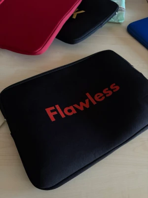 Svart datorväska med Flawless-tryck - Snygg svart datorväska med rött Flawless-tryck på framsidan. Priset kan diskuteras och bara höra av sig om de finns frågor. Fodralet är från safeCase Uf. 