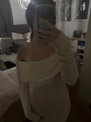 Offshoulder ribbad långklänning beige från monki  - Superfin långklänning i ribbat beige material med offshoulder-design och långa ärmar. Klänningen har en mjuk och stretchig passform som sitter snyggt på kroppen. Perfekt för dig som vill ha en stilren och trendig look.