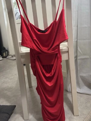 Röd klännig - Röd klänning som är väldigt stretchig. Den är ”öppen” framtill och har fin detalj strech baktill. Aldrig använd!