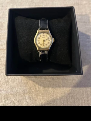 1950 Buler Swiss Mekanisk Fungerar! - Säljer ett nästintill uråldrigt damur från schweiziska Buler ca: 1950-tal. Vackert  dekorativt guldpläterat mönster runt urtavlan. Fungerande mekaniskt manuellt urverk! Fås i befintligt skick enligt bilder. Baksidan har gravyr, markering om rostfritt stål på franska samt modellbeteckningen 820.   Begagnat pris: < 1200 SEK Mitt pris: 489 SEK  Skickas alltid snabbt och spårbart (ofta samma dag) eller hämtas i Glumslöv.  Hör av dig vid frågor och se gärna mina andra annonser också!