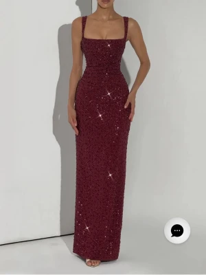 Vinröd baby boo klänning strl S - Säljer en vinröd långklänning med glittrande paljetter och breda axelband. Klänningen har en figurnära passform och rak nederkant, perfekt för dig som vill sticka ut på festen. Fyrkantig ringning och elegant siluett.