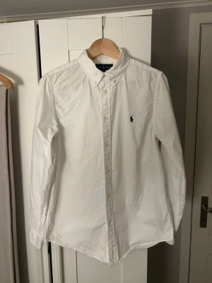 Polo Ralph Lauren Skjorta - Fet klassisk vit polo skjorta. Storlek 20. Små fläckar finns (se bild 4 och 5) men som knappt märks av och borde gå att tvätta.
