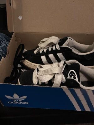 Adidas Originals svartvita sneakers - Säljer ett par campus sneakers i svart mocka med vita detaljer. Säljer då de inte kommer till användning längre och de är i superfint skick!💗💗