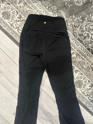 Svarta leggings  - Svarta leggings storlek xs, loggan sitter lite löst och den har en liten nagellim fläck på byxan (se bild) annars bra skick :)