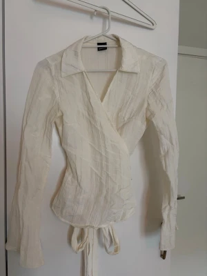 Gina tricot omlott blus  - En superfin omlott blus från Gina tricot i offwhite. Blusen knyts baktill och har en krage. Superfin blus! 🌼