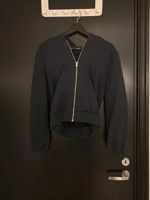Mörkblå hoodie/sipptröja  - Snygg börkblå hoodie från 157 i storlek XS. Hoodien har en stor huva, dragkedja framtill och en rymlig magficka. Tillverkad i mjukt sweatshirtmaterial som är perfekt för chill dagar. Lätt att matcha med jeans eller mjukisbyxor.