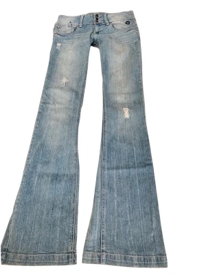 Ljusblå vintage superlågmidjade jeans - Sååå sjukt snygga vintage superlågmidjade bootcut jeans med slitna detaljer och SÅÅ långa 💓💓 midjemått: 38 cm Innebenslängd: 89 cm 
