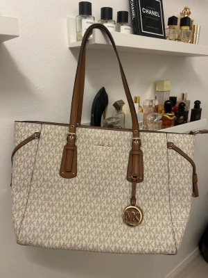 Michael Kors Voyager Tote Vanilla - Stilren handväska från Michael Kors i modellen Voyager Tote. Helt ny! Lådan/kartongen till väskan medföljer :)