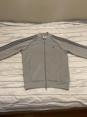 Adidas Originals - Ljusgrå Adidas Originals jacka i storlek Large. Knappt använd så i väldigt bra skick. 