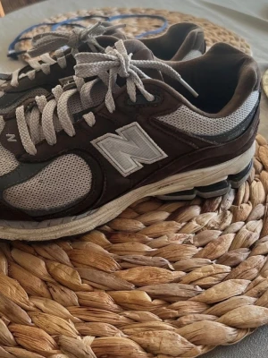 New Balance 2002R sneakers stl 42 bruna/grå - New Balance 2002R sneakers i stl 42, bruna/ grå.. Sköna sulor med bra dämpning.  Kan skickas omkring den 4 maj, är på semester.