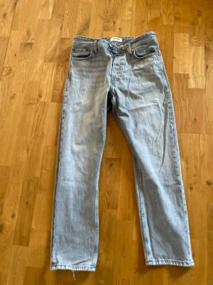 Ljusgrå loose fit jeans Jack & Jones - Säljer ett par ljusgrå loose fit jeans från Jack & Jones. Jeansen har klassisk femficksdesign, raka ben och är tillverkade i bomullsdenim. Perfekta för en avslappnad och trendig look.