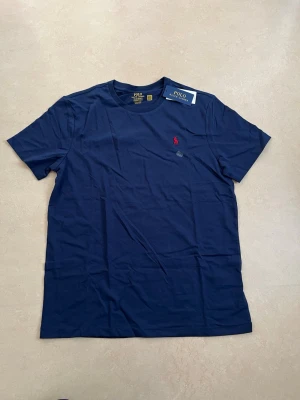 Ralph lauren T-shirt mörkblå storlek large  - Ny Ralph Lauren t-shirt med klassisk passform. Perfekt basplagg till sommaren.  Oanvänd Väldigt populär modell Enkel att matcha  Skickas snabbt 📦 Rabatt vid köp av flera.